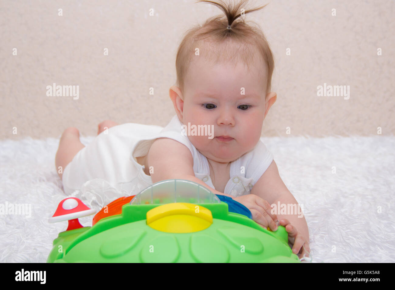 Little baby girl playing with a toy Stock Photo - Alamy