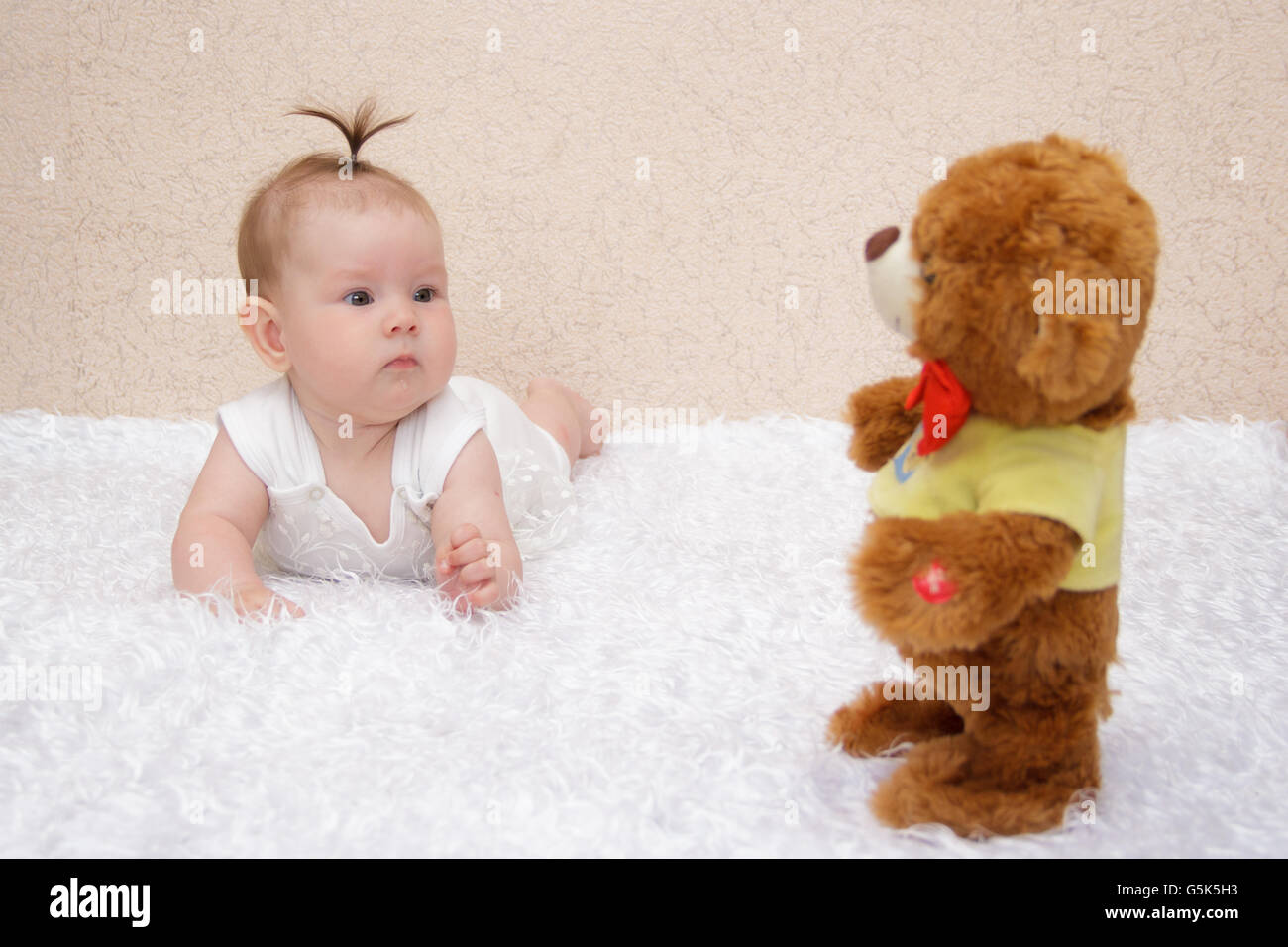 Little baby girl playing with a toy teddy bear Stock Photo - Alamy