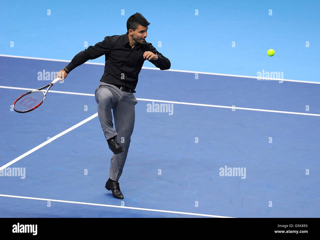 Manchester City striker Sergio Aguero kicks a tennis ball as he plays tennis with Argentina's Juan Martin del Potro (not pictured) following del Potro's match against Serbia's Janko Tipsarevic during the Barclays ATP World Tour Finals at the O2 Arena, London. Stock Photo