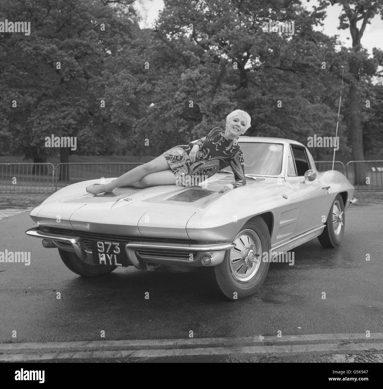 Lisa Noble reclines on the bonnet of her Chevrolet Stingray car in Hyde Park, London. A former telephone switchboard operator, she was given the vehicle by her husband to celebrate her success as a cabaret performer at the Showboat Theatre Restaurant in the Strand. *Low res scan - hi res available on request* Archive-PA128368-1 Stock Photo