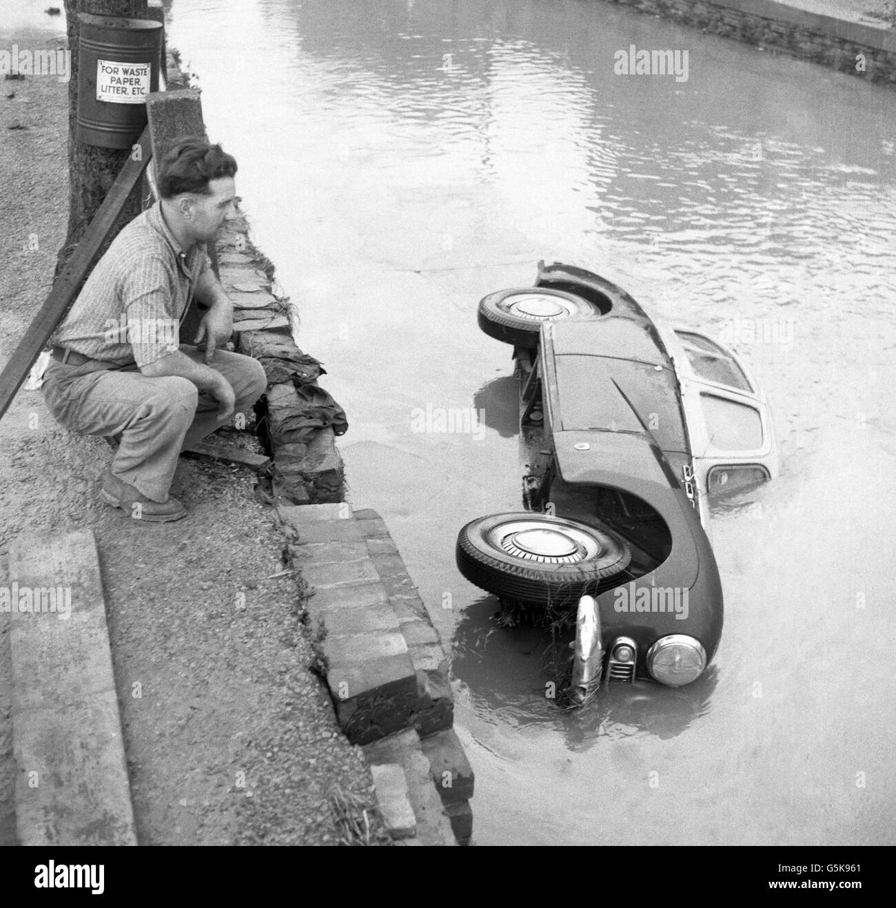 A Sunbeam Mk III car lies in a river after being swept several hundred yards from the centre of Horncastle, following severe floods. Stock Photo