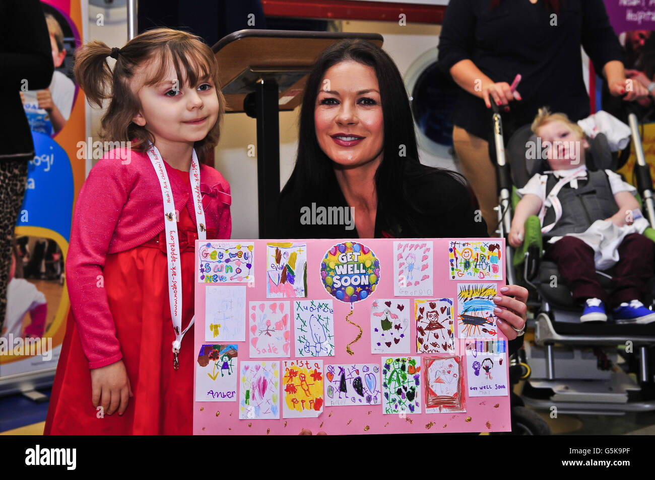 Catherine Zeta Jones presents a get-well-card to Neve Ritchie, 6, from Pontypridd, from all her friends in Miss Armishaw's, year 2 class, at Hwathorn Primary School, Pontypridd, after she took part in a renaming ceremony for Noah's Ark Children's Hospital of Wales, a specialist facility in the Welsh capital of Cardiff, and to help launch a fundraising drive. Stock Photo