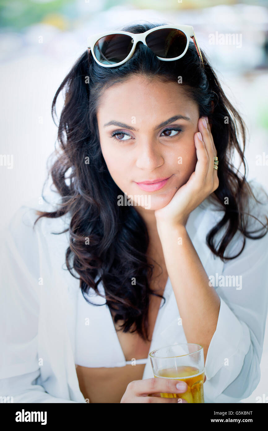 Hispanic woman drinking cocktail outdoors Stock Photo