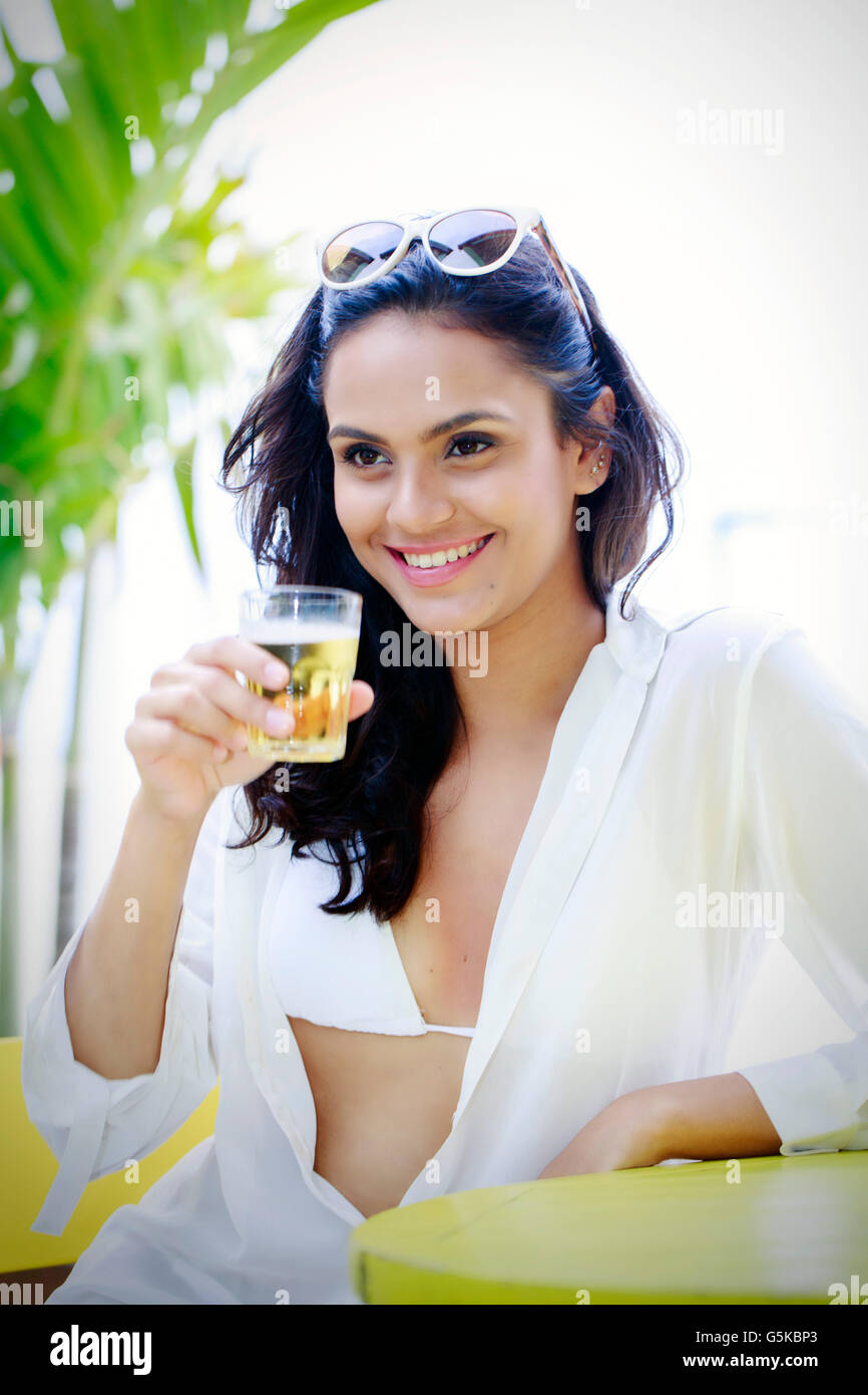 Hispanic woman drinking cocktail outdoors Stock Photo