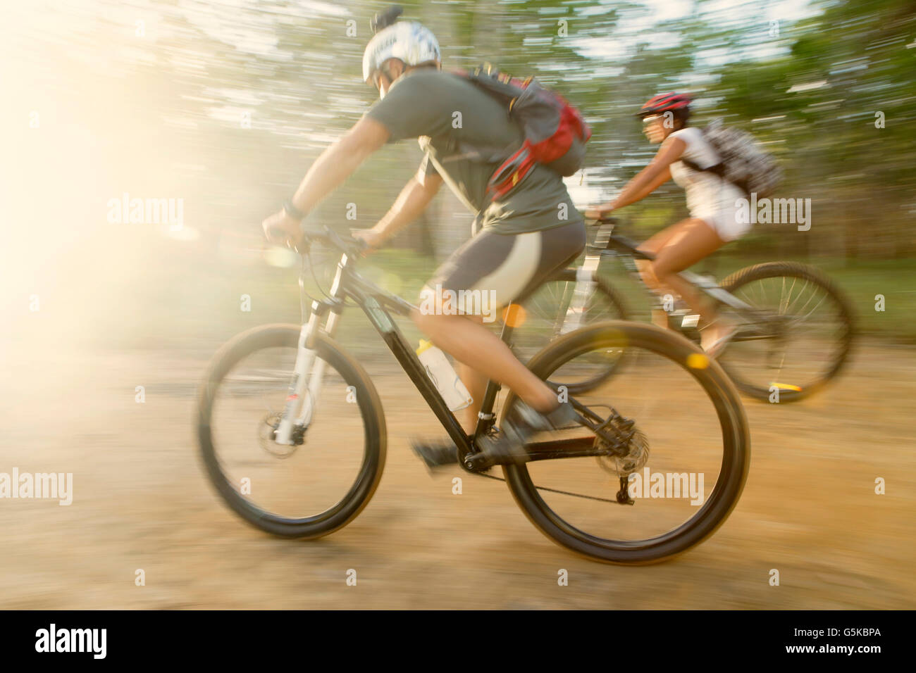 Blurred view of couple riding mountain bikes Stock Photo