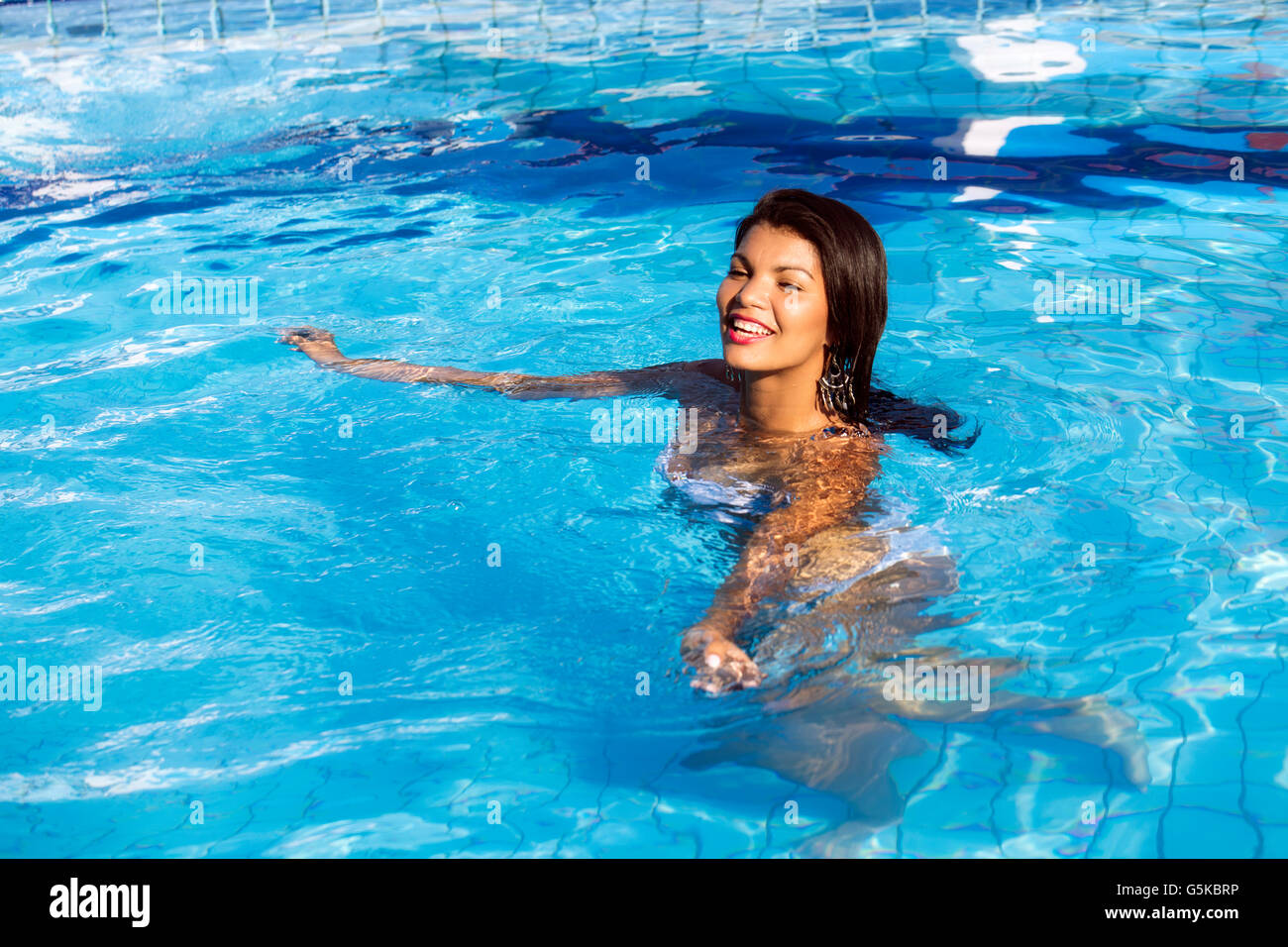 Hispanic woman swimming in pool Stock Photo