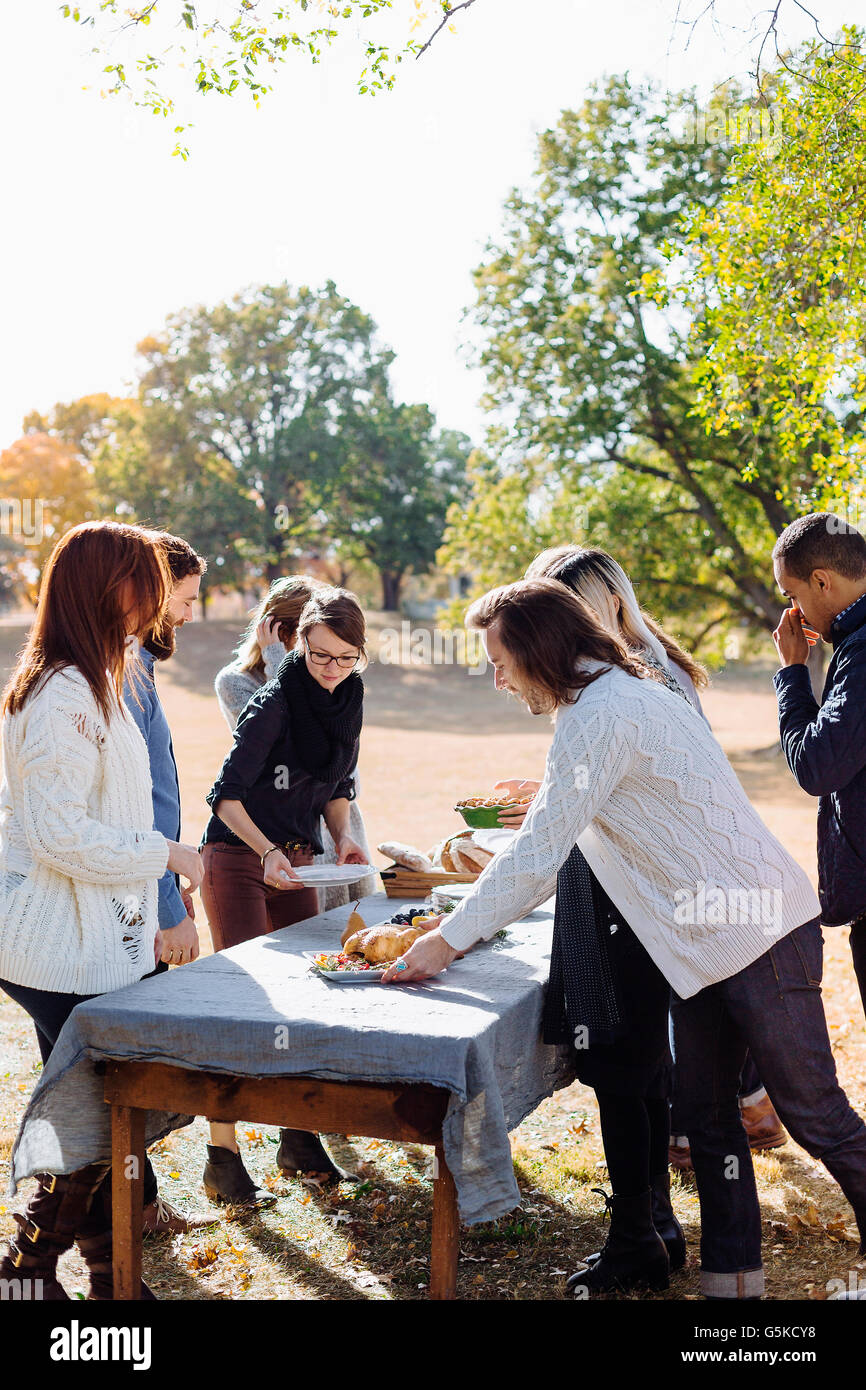 Friends setting outdoor dining table Stock Photo - Alamy