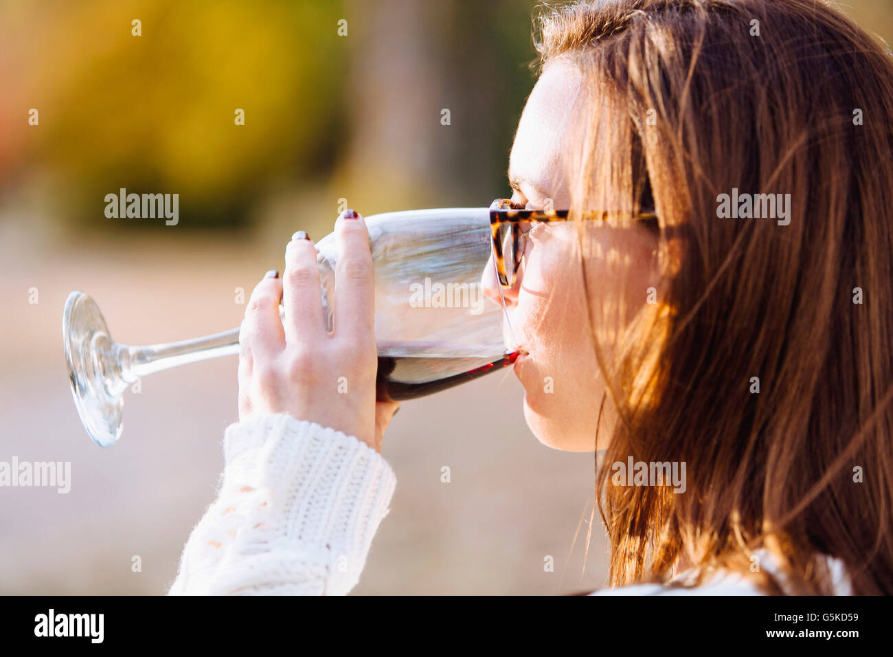 Caucasian woman drinking wine outdoors Stock Photo