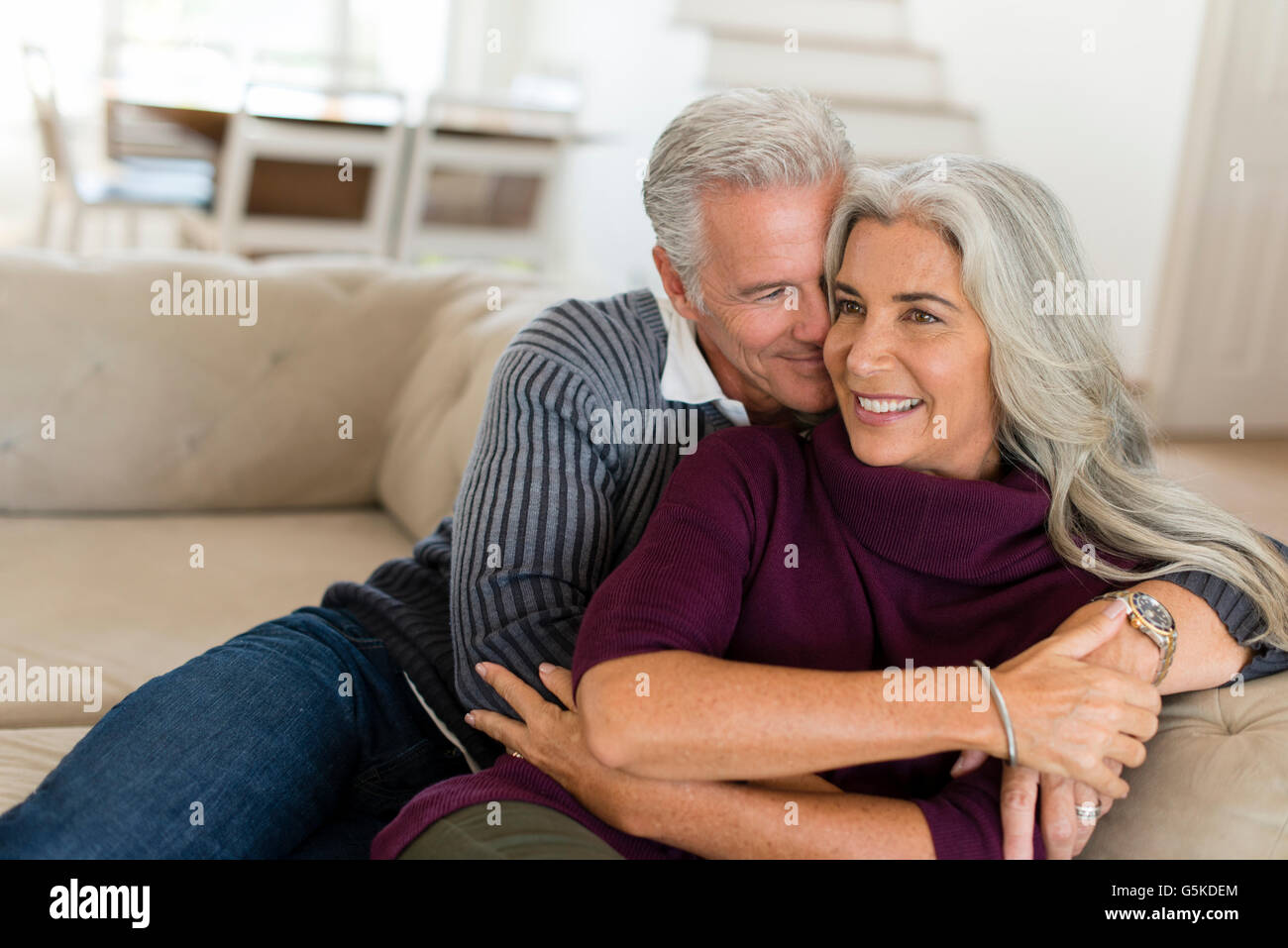 Caucasian couple hugging on sofa Stock Photo