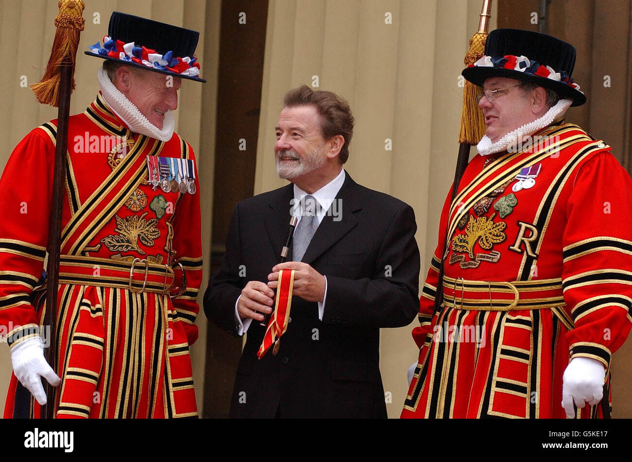 Flute player Sir James Galway meets yeomans Ray Duffy (right) and Graham Dear (left) after receiving his knighthood from the Queen at Buckingham Palace. Stock Photo