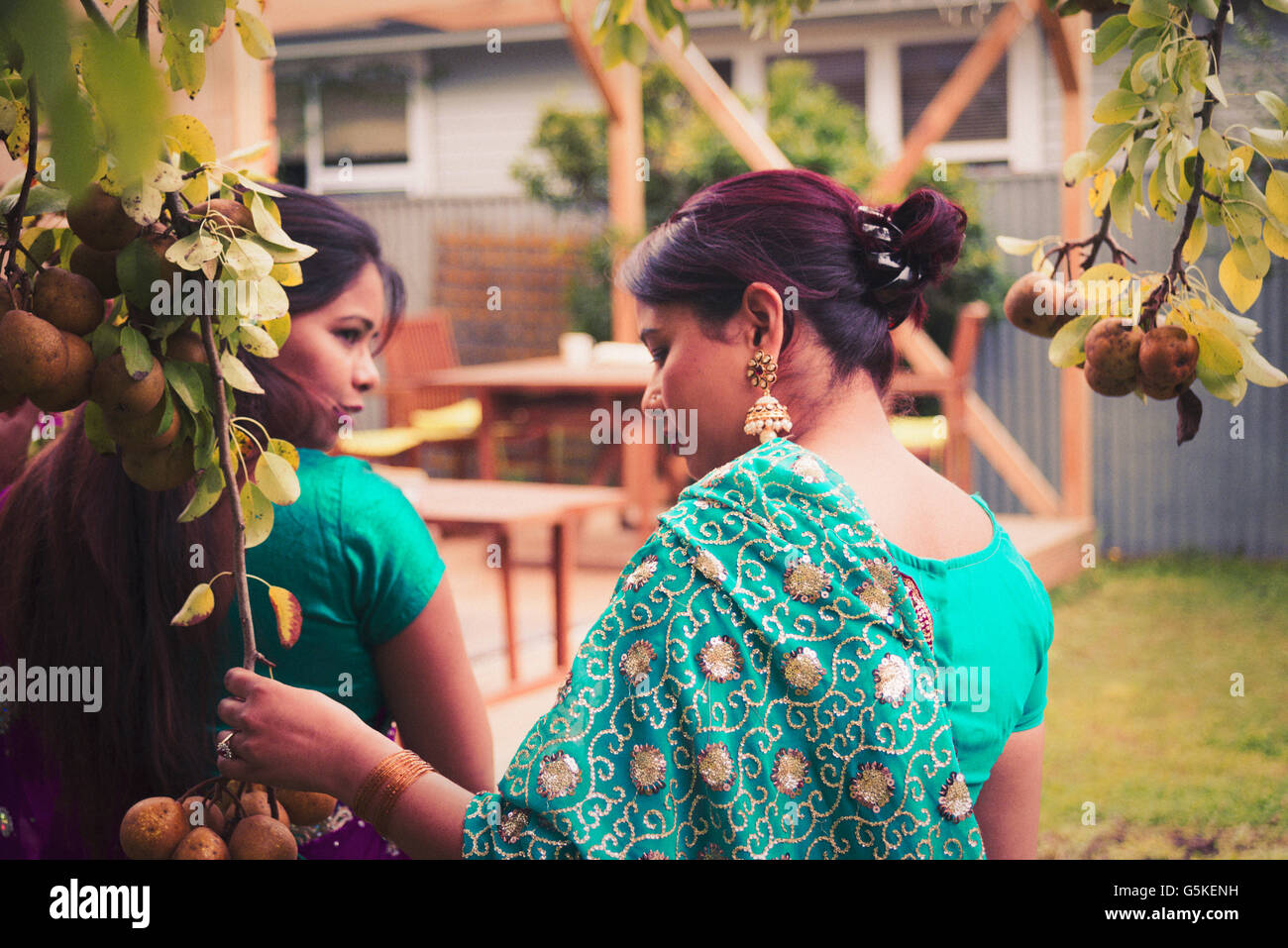 Women wearing Indian dresses in backyard Stock Photo