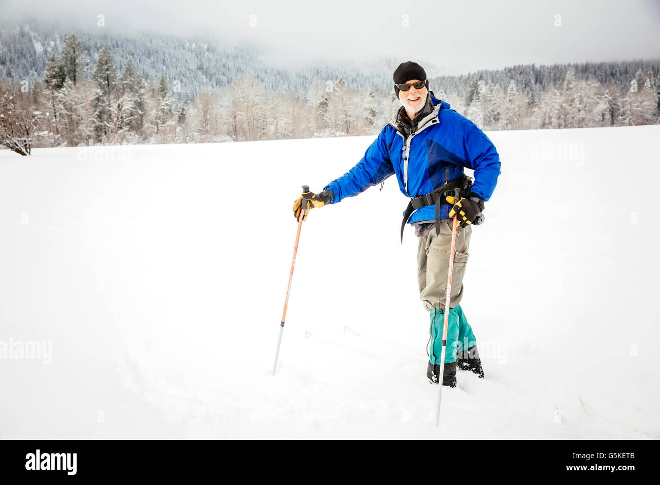 Caucasian woman cross-country skiing in snowy field Stock Photo