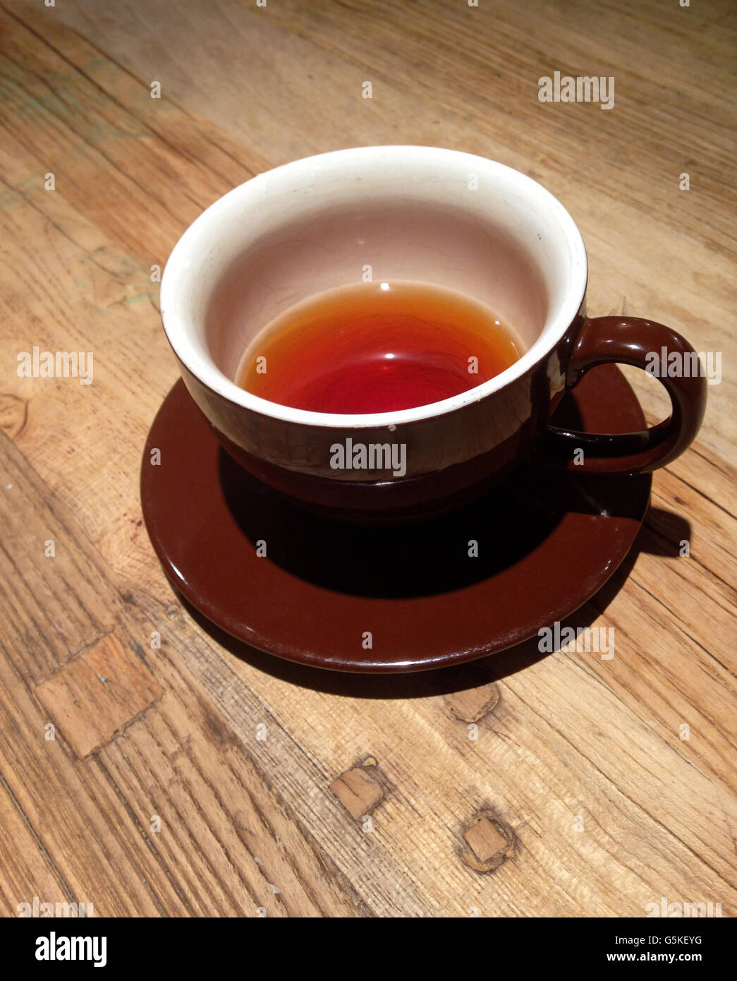 Cup of tea with saucer on wood surface Stock Photo