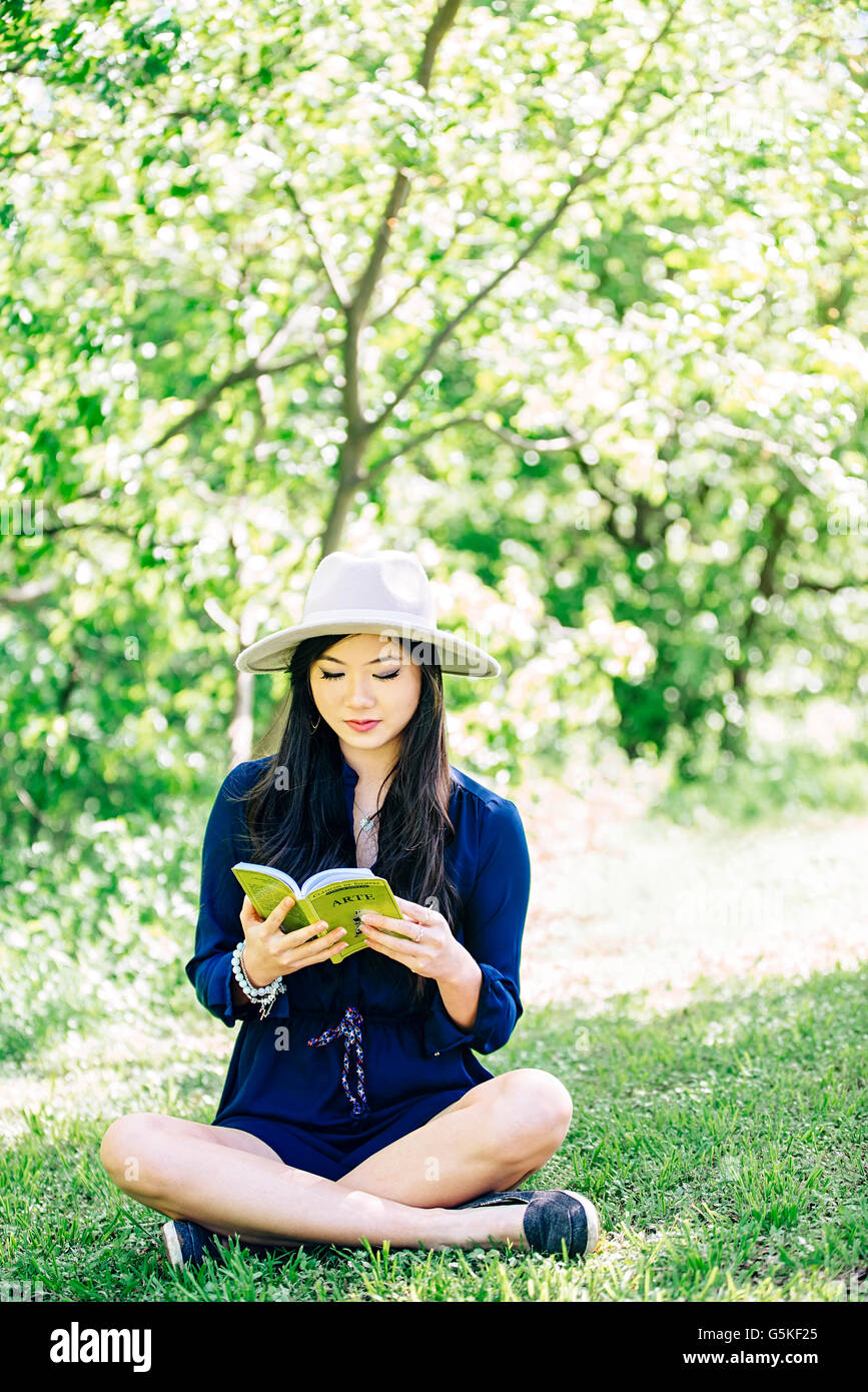 Chinese woman reading in garden Stock Photo