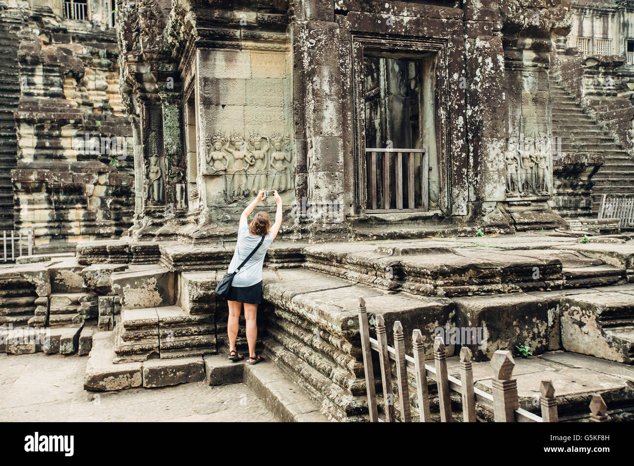 Caucasian tourist photographing Angkor Wat ruins, Siem Reap, Cambodia Stock Photo