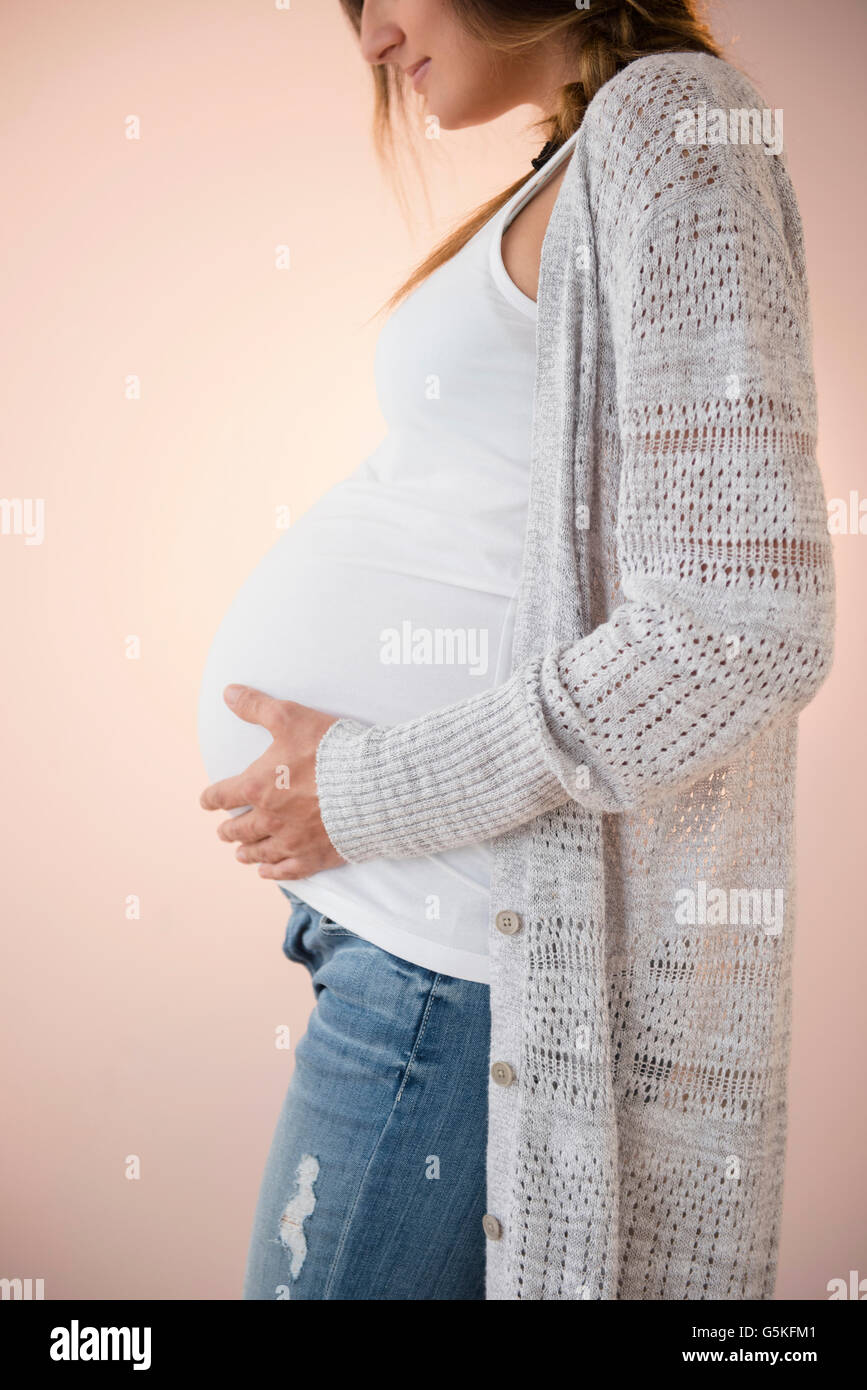 Pregnant Caucasian woman holding her belly Stock Photo - Alamy