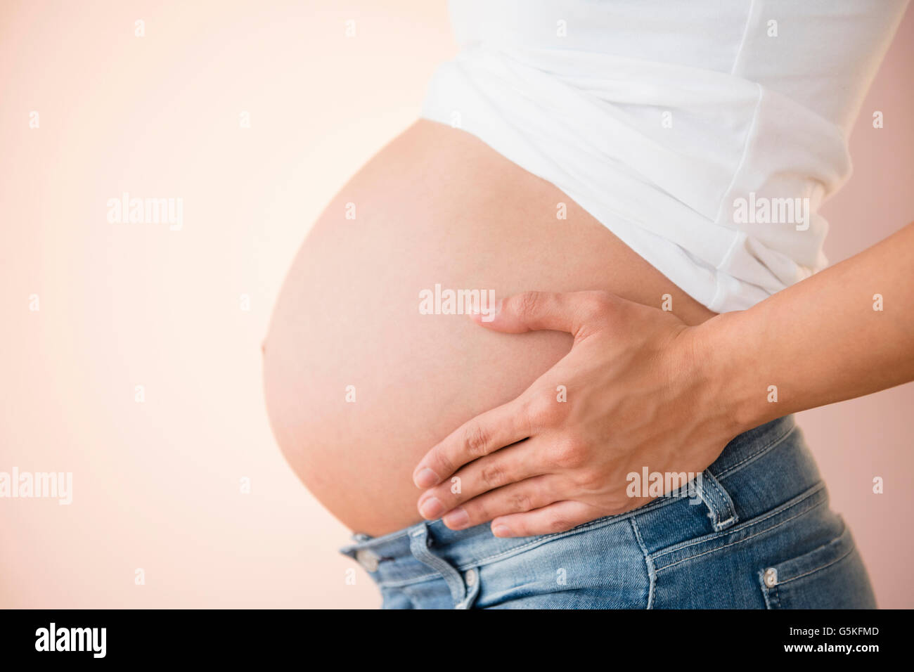 Pregnant Caucasian woman holding her belly Stock Photo - Alamy