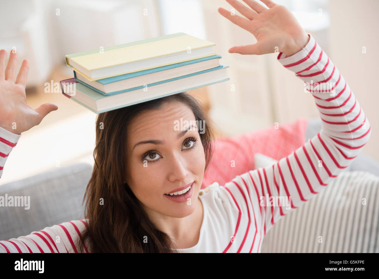 Woman balancing books on head Stock Photo
