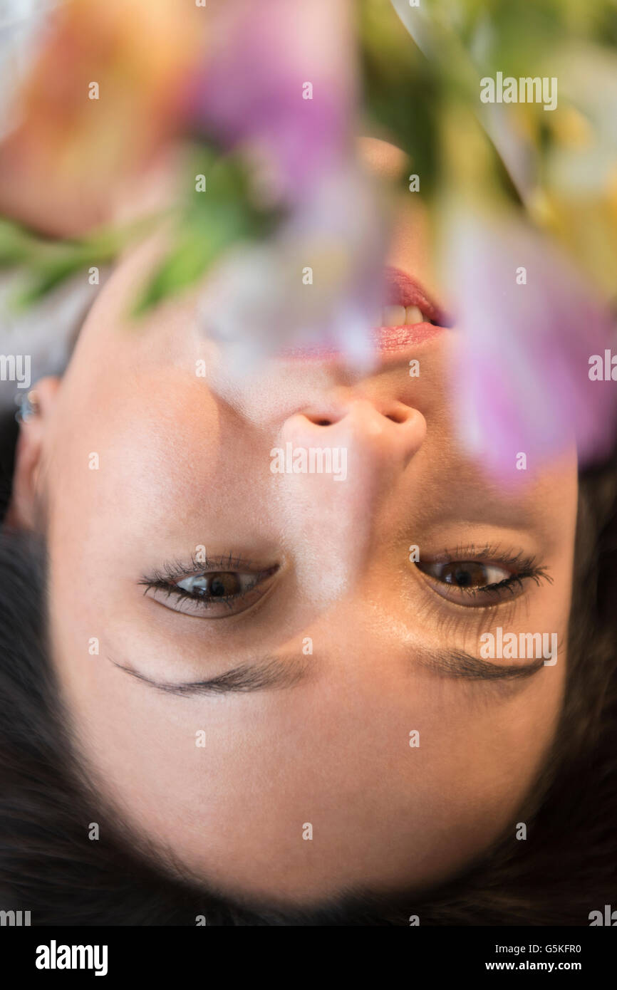 Face of smiling woman obscured by flowers Stock Photo - Alamy
