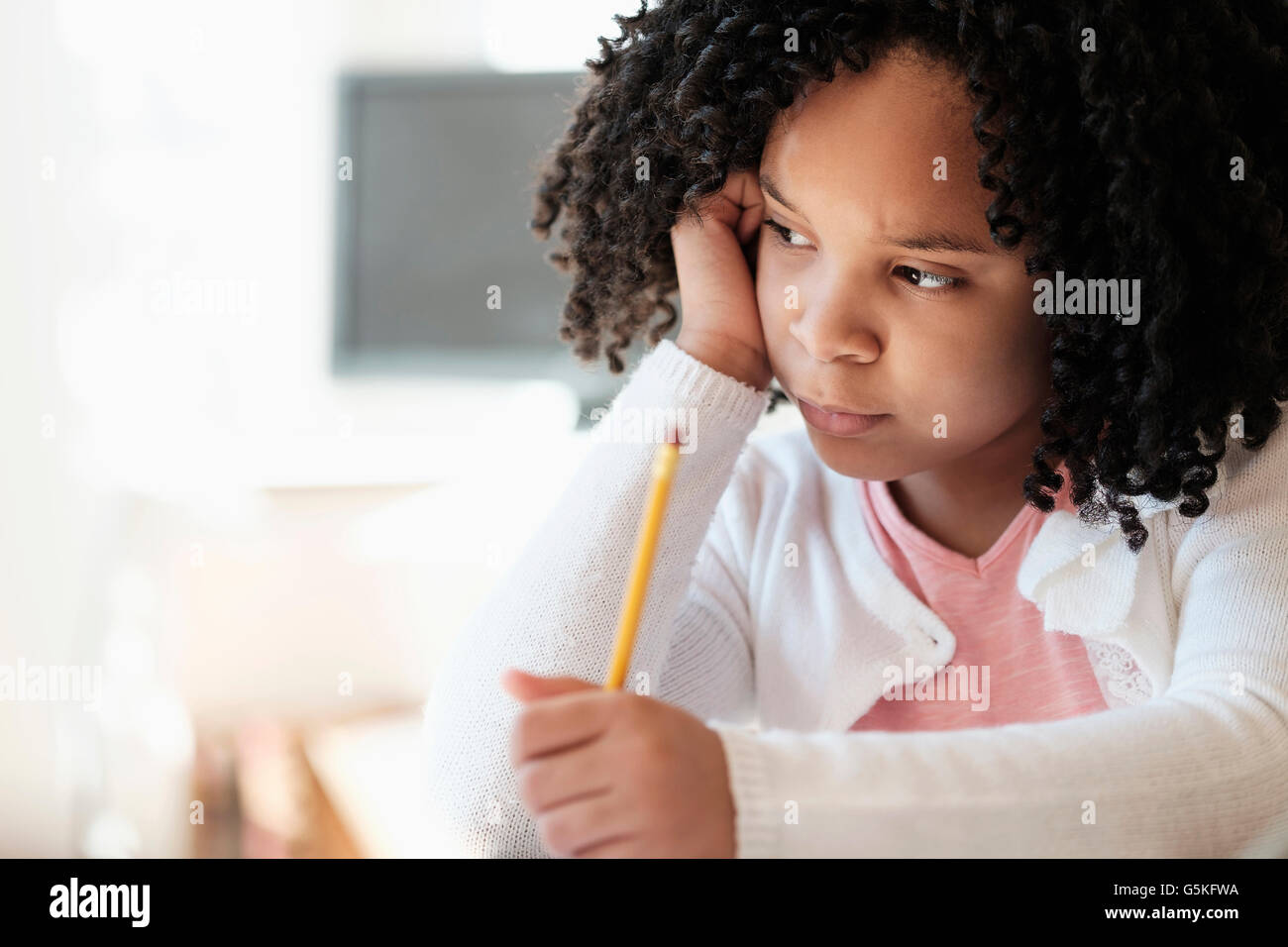 African American student writing in classroom Stock Photo