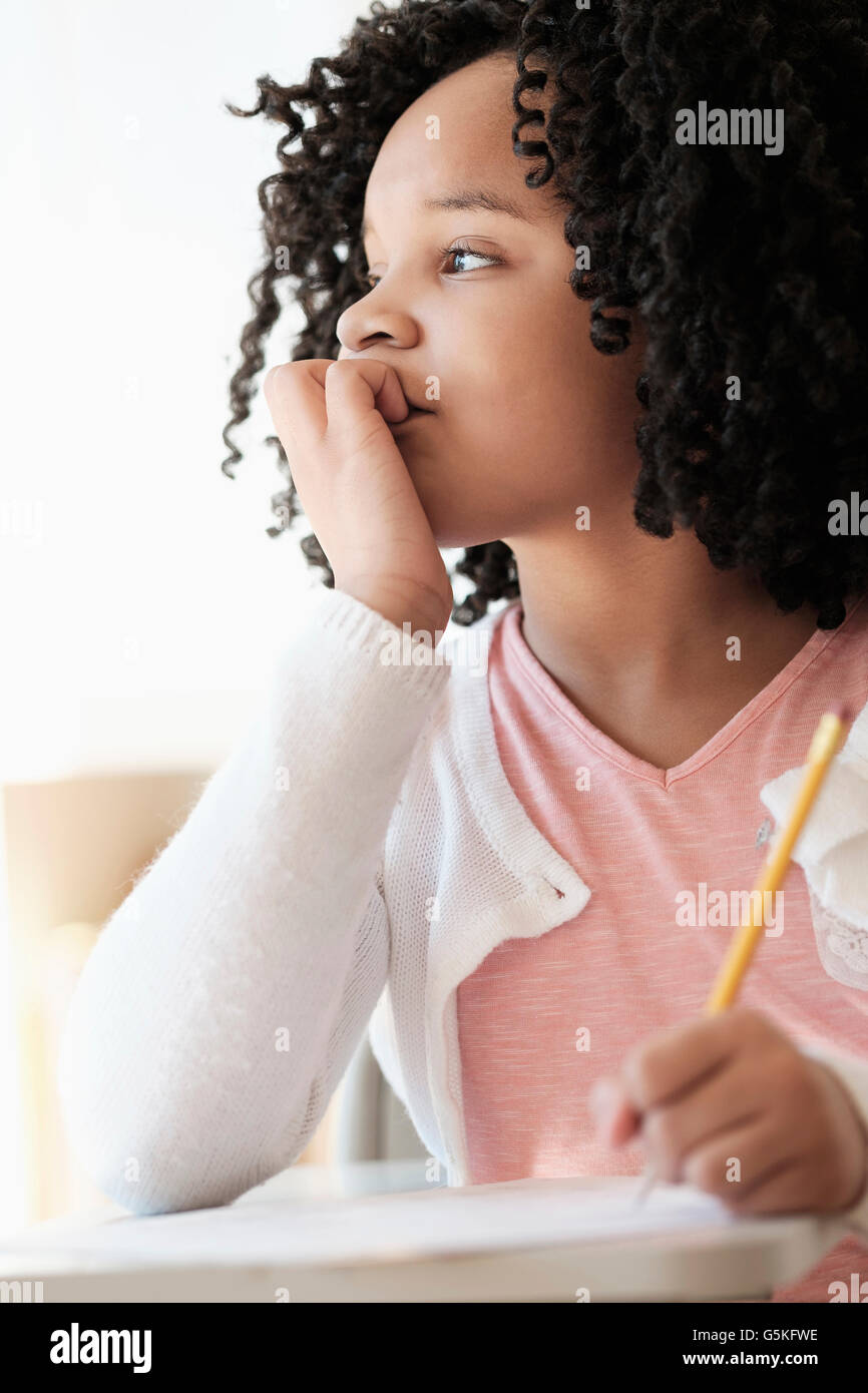 African American student writing in classroom Stock Photo