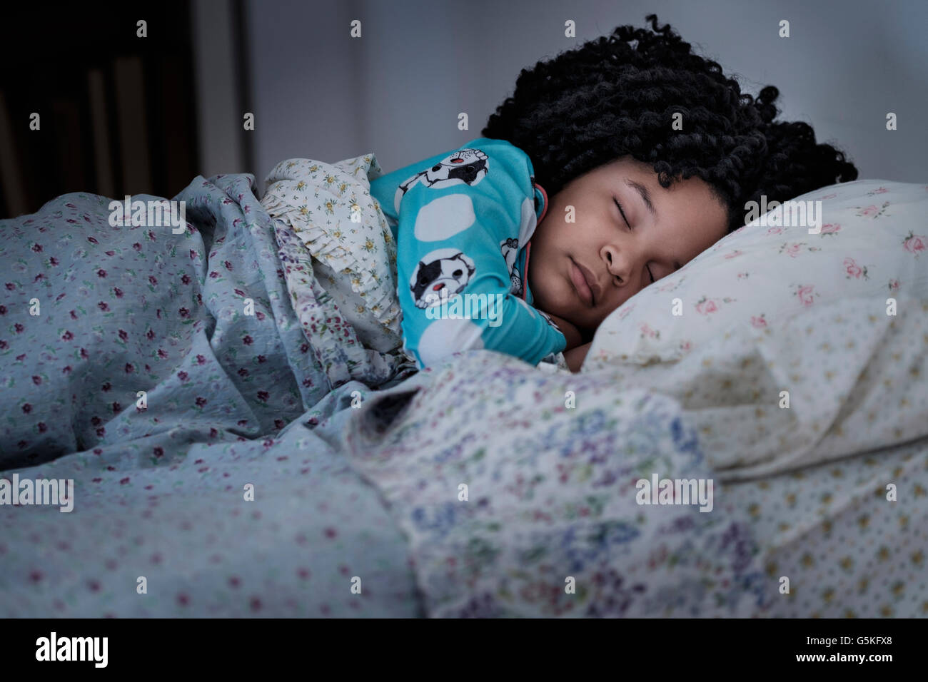 African American girl sleeping in bed Stock Photo
