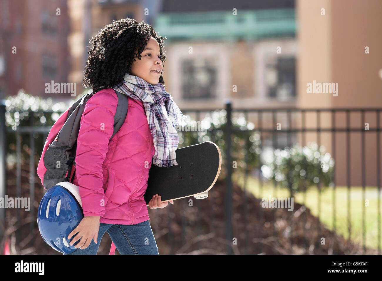African American girl carrying skateboard outdoors Stock Photo
