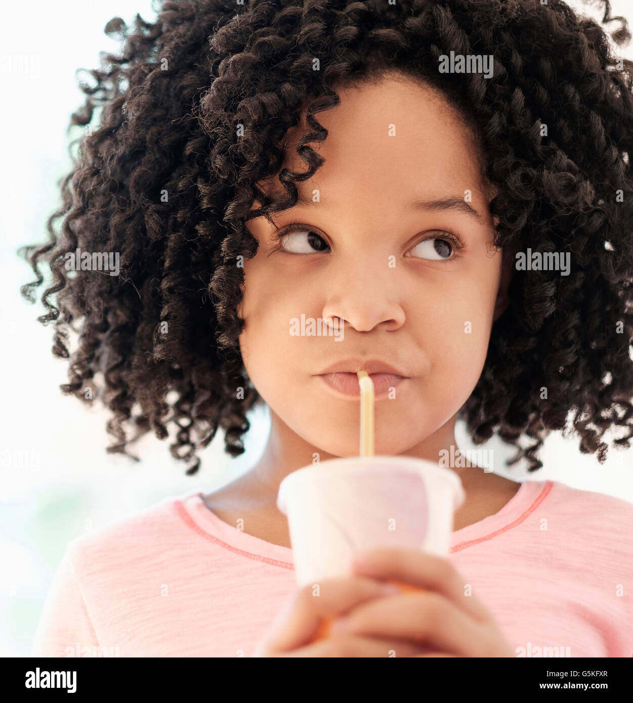 African American girl drinking with straw Stock Photo
