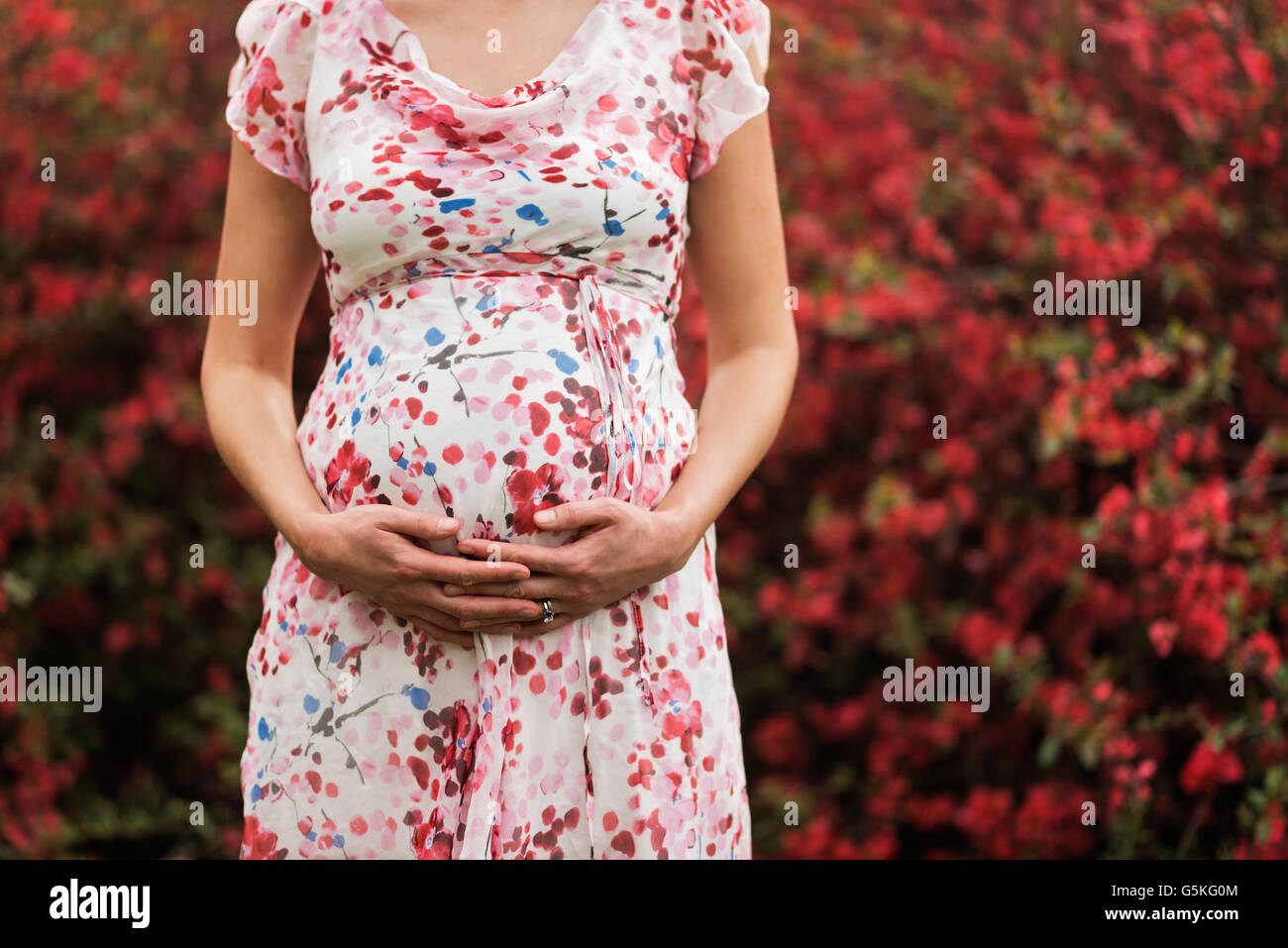 Pregnant Caucasian woman holding her belly outdoors Stock Photo - Alamy