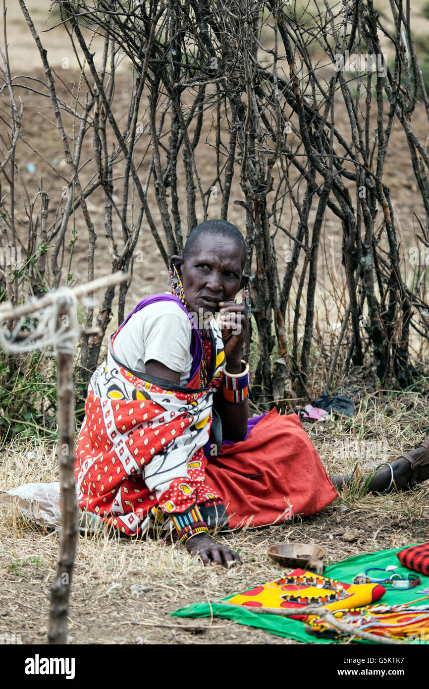 Old Masai woman sitting in the Masai village in Kenya, Africa. Stock Photo