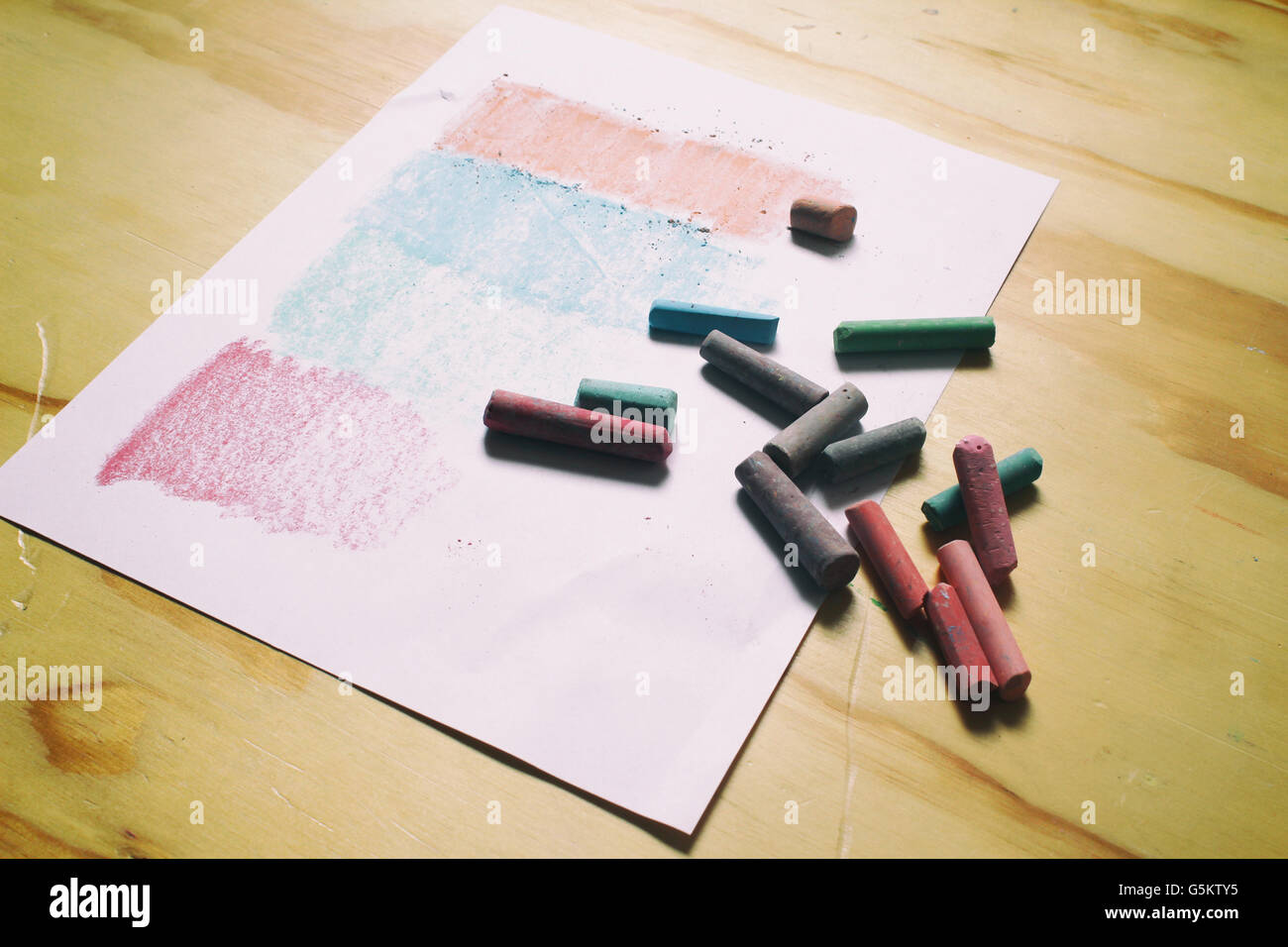 Photograph of a sheet of paper and color chalks in a retro style on a wood table Stock Photo