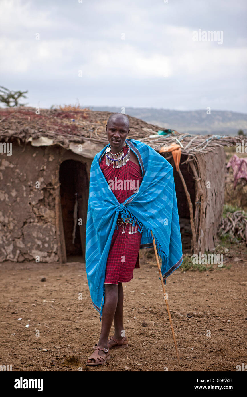 Masai warrior standing in front of a mud hut in the Masai Village, Kenya, Africa. Stock Photo