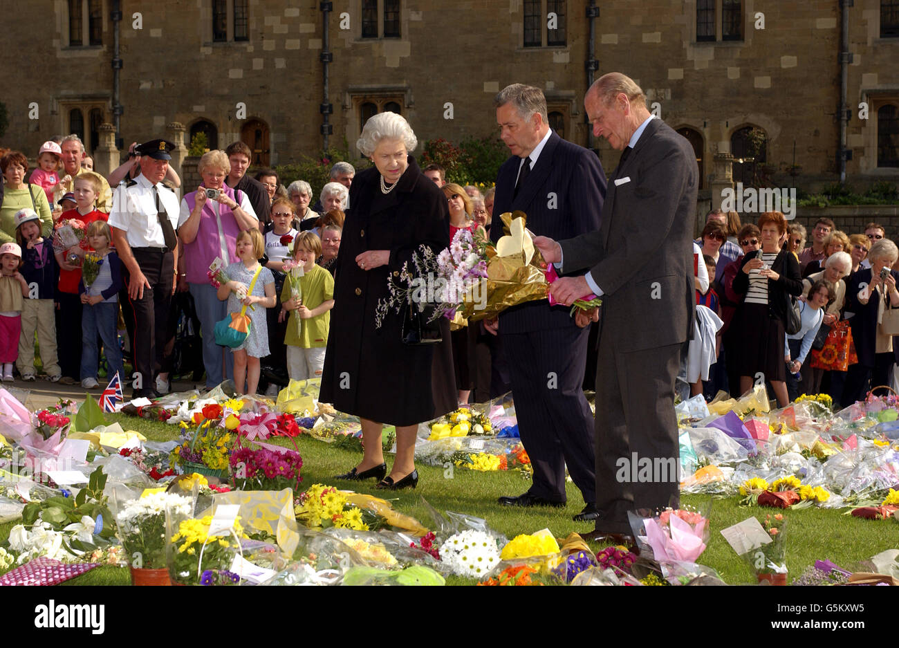 Britain's Queen Elizabeth II and the Duke of Edinburgh accompanied by the Superintendent of Windsor Castle, Munro Davidson (centre), look at flowers left in the castle grounds by well wishers honouring the death last week of Queen Elizabeth, The Queen Mother. Stock Photo