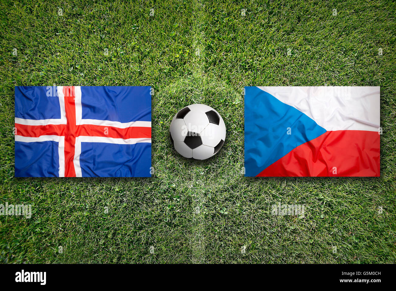 Iceland vs. Czech Republic flags on green soccer field Stock Photo
