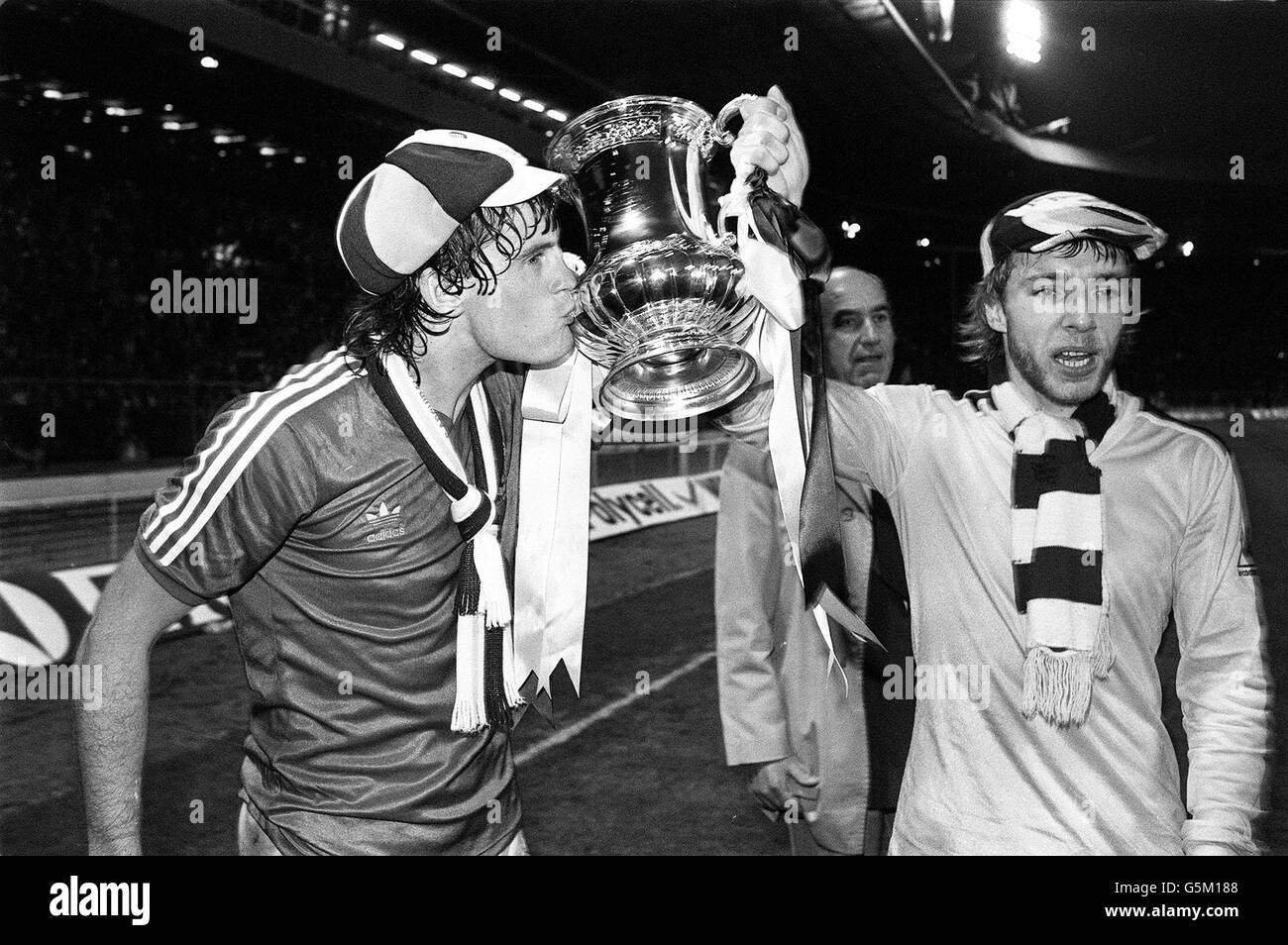 Tottenham's Glenn Hoddle kisses the cup as he and Steve Archibald take it on a lap of honour after defeating Queen's Park Rangers 1-0 in the FA Cup final. Stock Photo