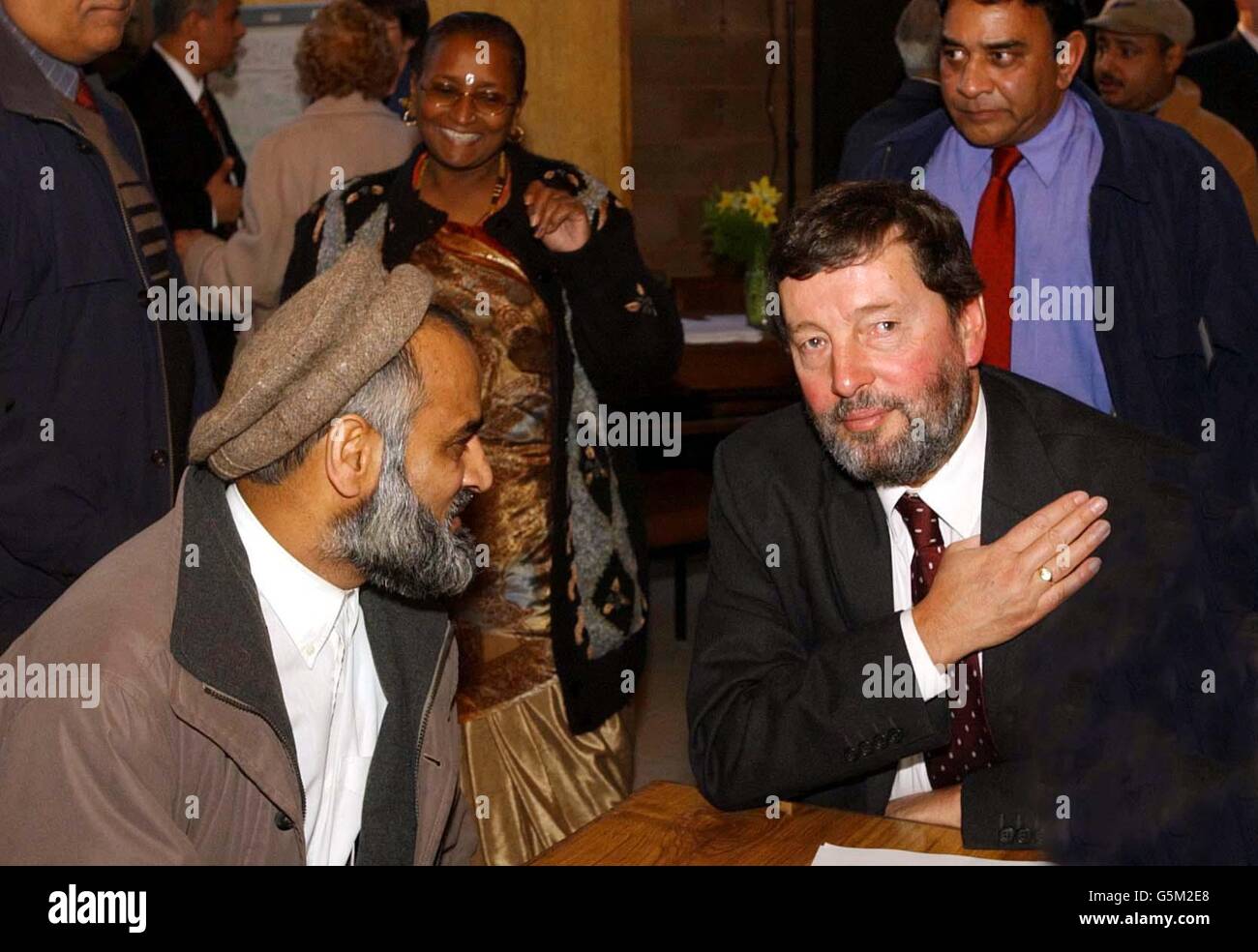 Home Secretary David Blunkett talks with Zualfqar Hussain of Small Heath during his visit to a multi-faith community centre in Balsall Heath in Birmingham. * ..... Immigrants should have to swear an oath of allegiance to show their clear primary loyalty to Britain, a report into race riots. The controversial suggestion in the Cantle Report, which was commissioned by Blunkett, goes even further than his recent comments that new arrivals should learn English and adopt British norms. Stock Photo