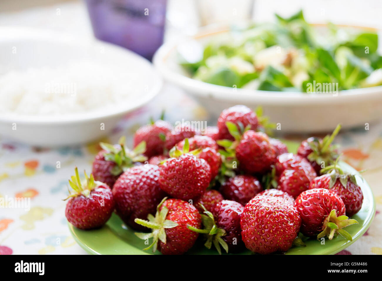 fresh organic strawberries in a green dish Stock Photo