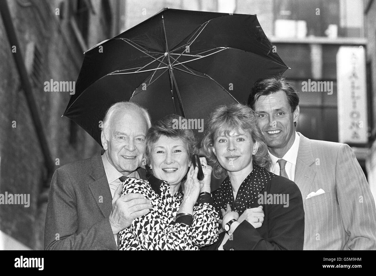 The cast of BBC One's comedy programme 'Don't Wait Up' take cover from the sun under an umbrella in London, after the launch of the fifth series of the father and son saga. The first episode features, from left, Tony Britton, Dinah Sheridan, Jane Booker and Simon Williams. Actor Nigel Havers was absent from the today's launch as he was suffering from laryngitis. Stock Photo