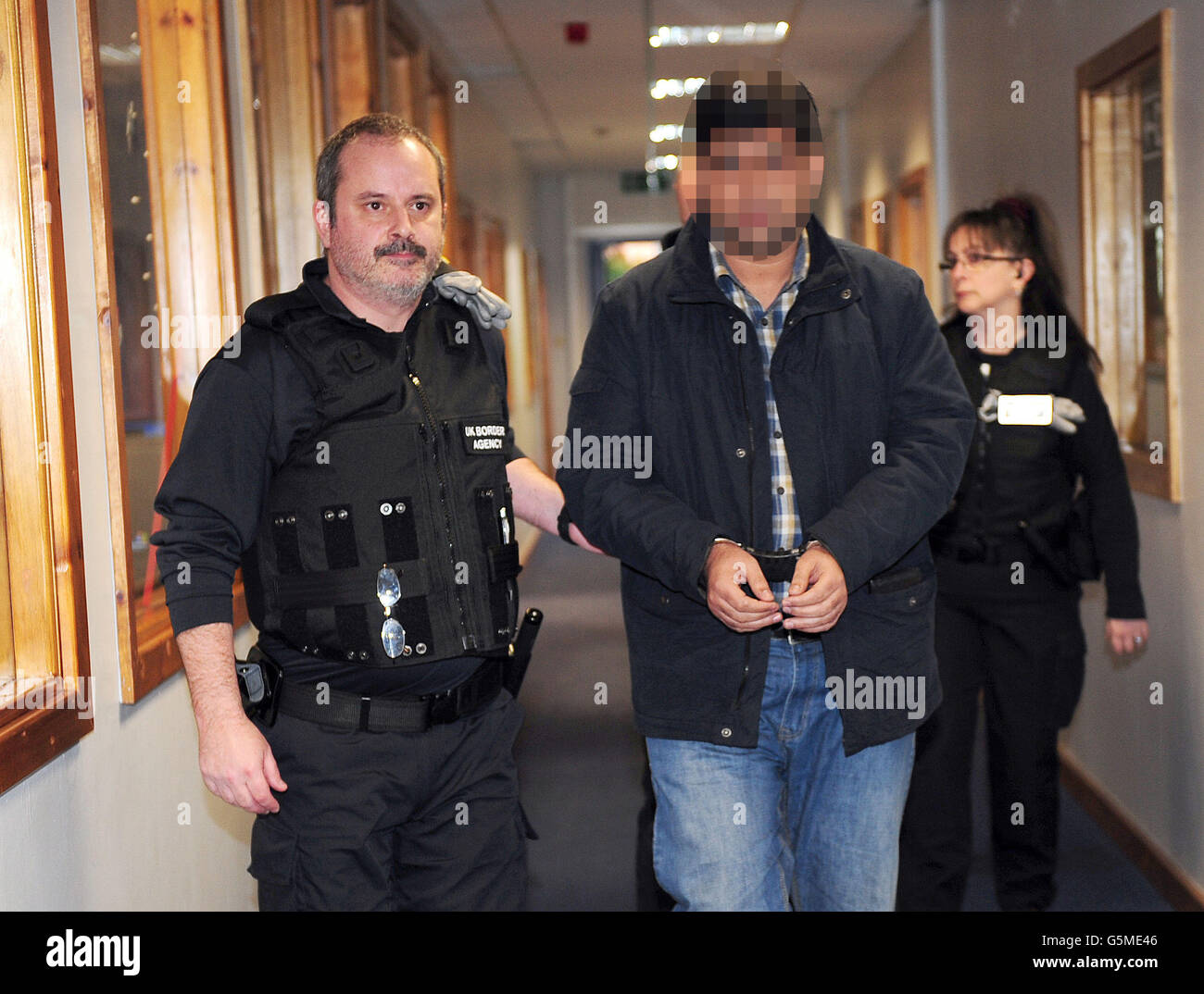 FACE PIXILATED BY PA PICTURE DESK A member of staff is arrested as part of a UK Border Agency raid into suspected immigration offences at Leeds Professional College, Leeds. Stock Photo