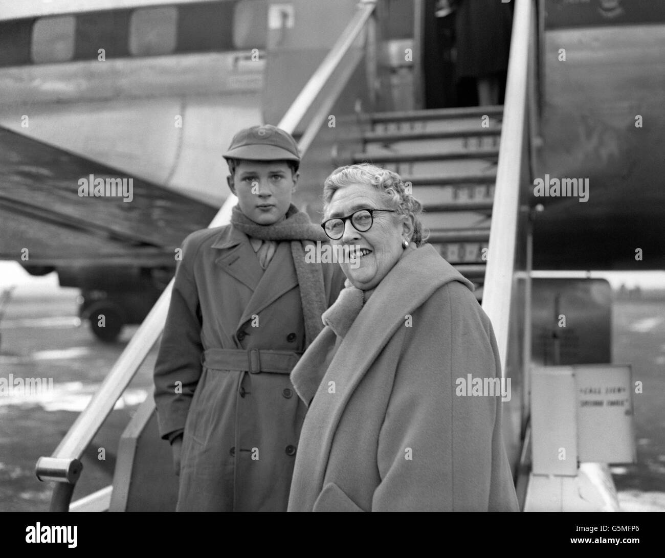 Novelist and playwright Agatha Christie and her grandson, Matthew Pritchard, leave London Airport to spend Christmas in Tripoli. Stock Photo