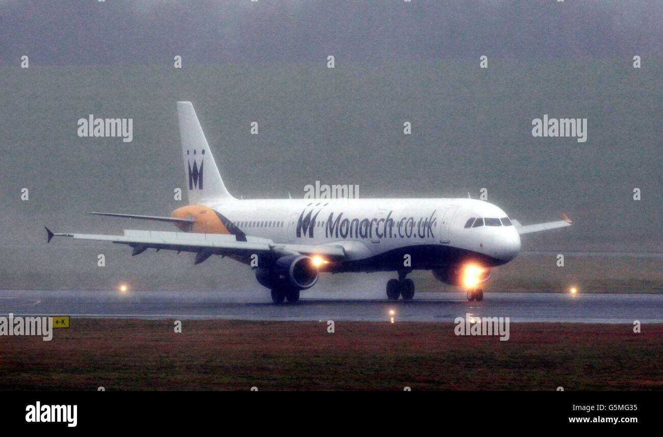 A Monarch Airways plane lands at a wet Birmingham Airport today as the aircraft maintenance division of the travel group has announced plans to build a new facility at Birmingham Airport, creating up to 300 jobs. Stock Photo
