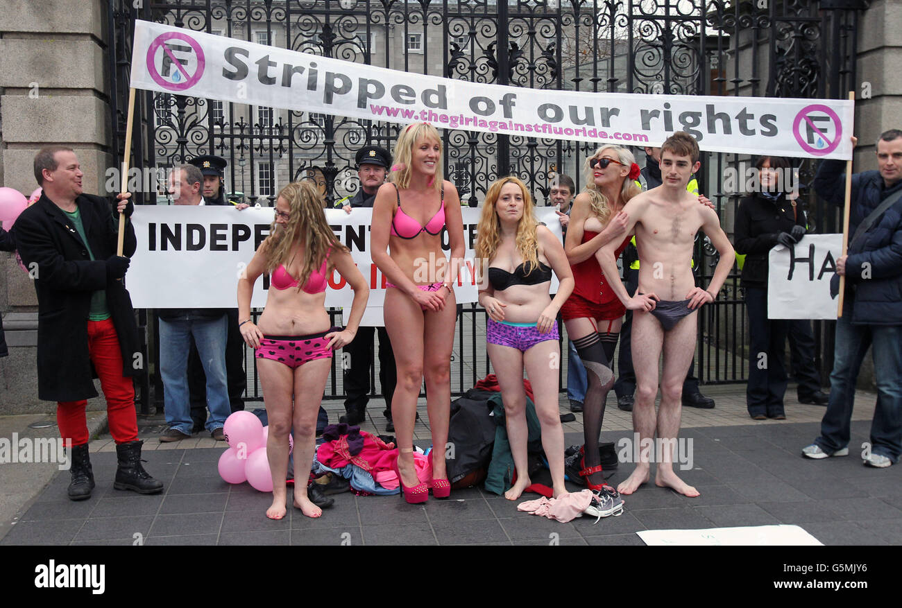 Aisling Fitzgibbon (front, 3rd left) aka 'The Girl Against Fluoride' with supporters as they strip off outside Leinster House to highlight the cost of the addition of chemicals including fluoride to the water supply as trade union members march through Dublin City Centre in opposition to Austerity. Stock Photo