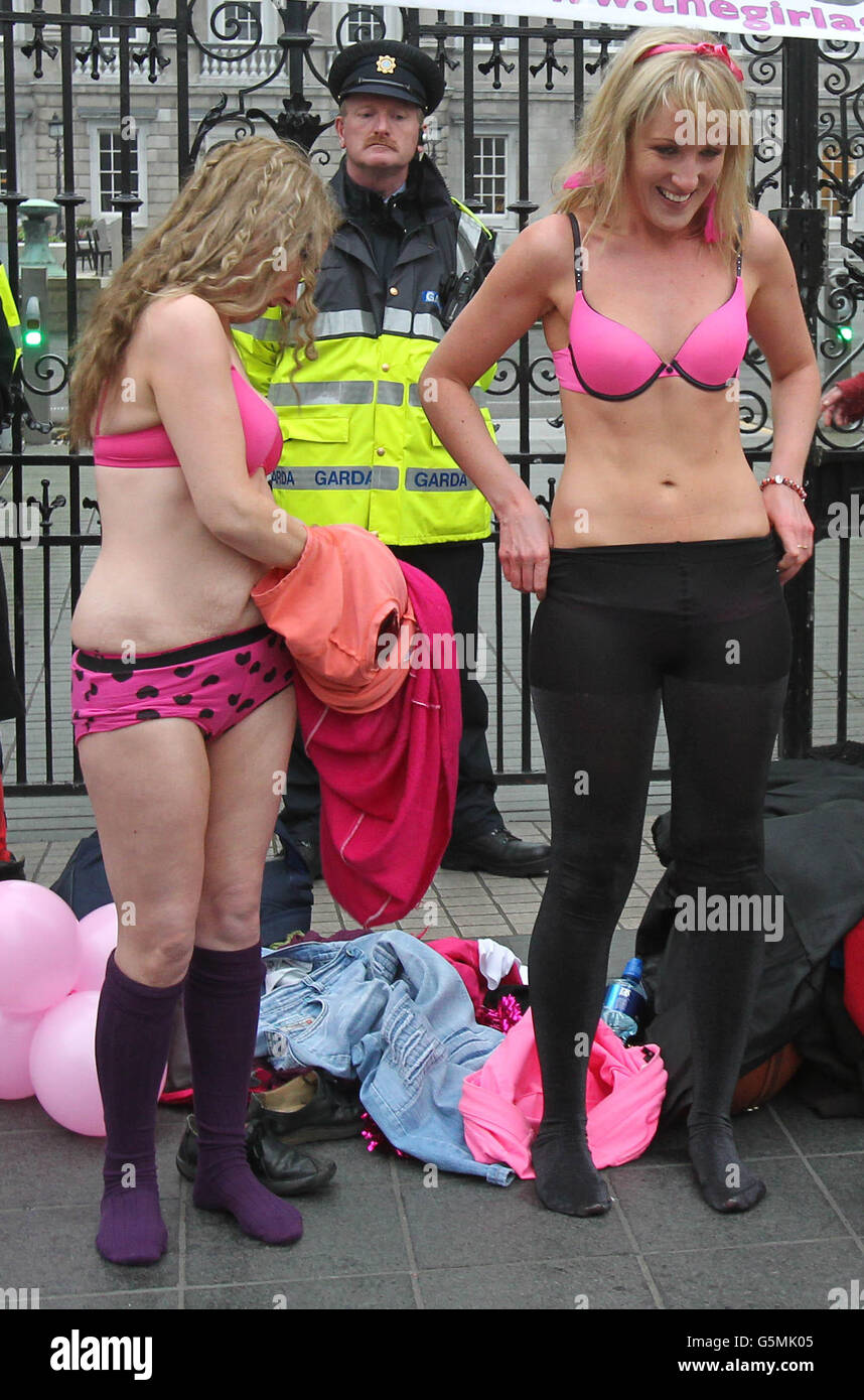 Aisling Fitzgibbon (right) aka 'The Girl Against Fluoride' with a supporter as they strip off outside Leinster House to highlight the cost of the addition of chemicals including fluoride to the water supply as trade union members march through Dublin City Centre in opposition to Austerity. PRESS ASSOCIATION Photo. Picture date: Saturday November 24, 2012. Photo credit should read: Niall Carson/PA Wire Stock Photo