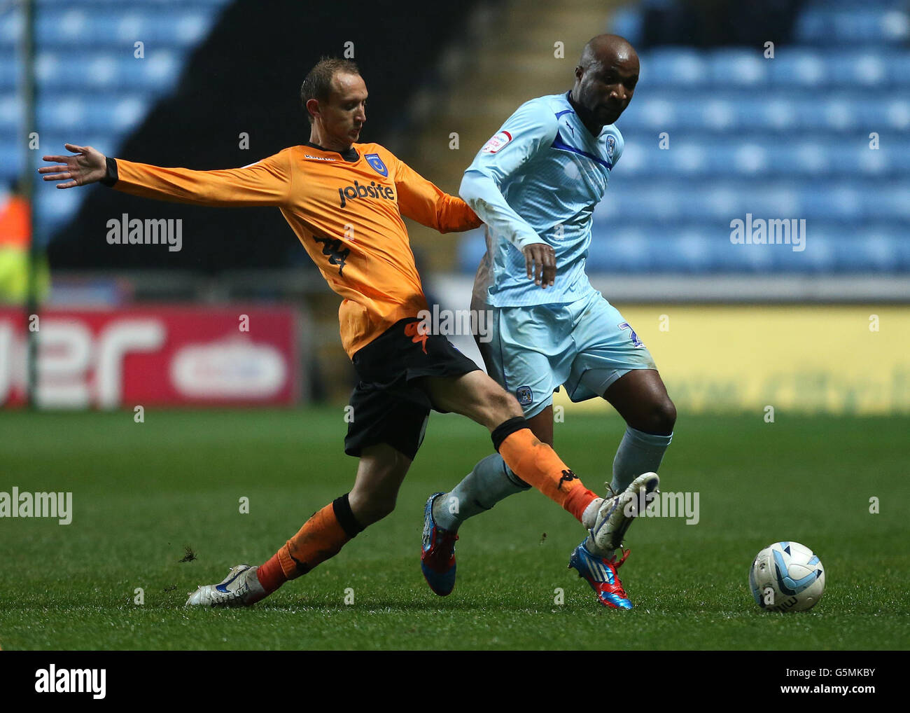 Coventry City's William Edjenguele and Portsmouth's Paul Benson during the npower Football League One match at the Ricoh Arena, Coventry. Stock Photo