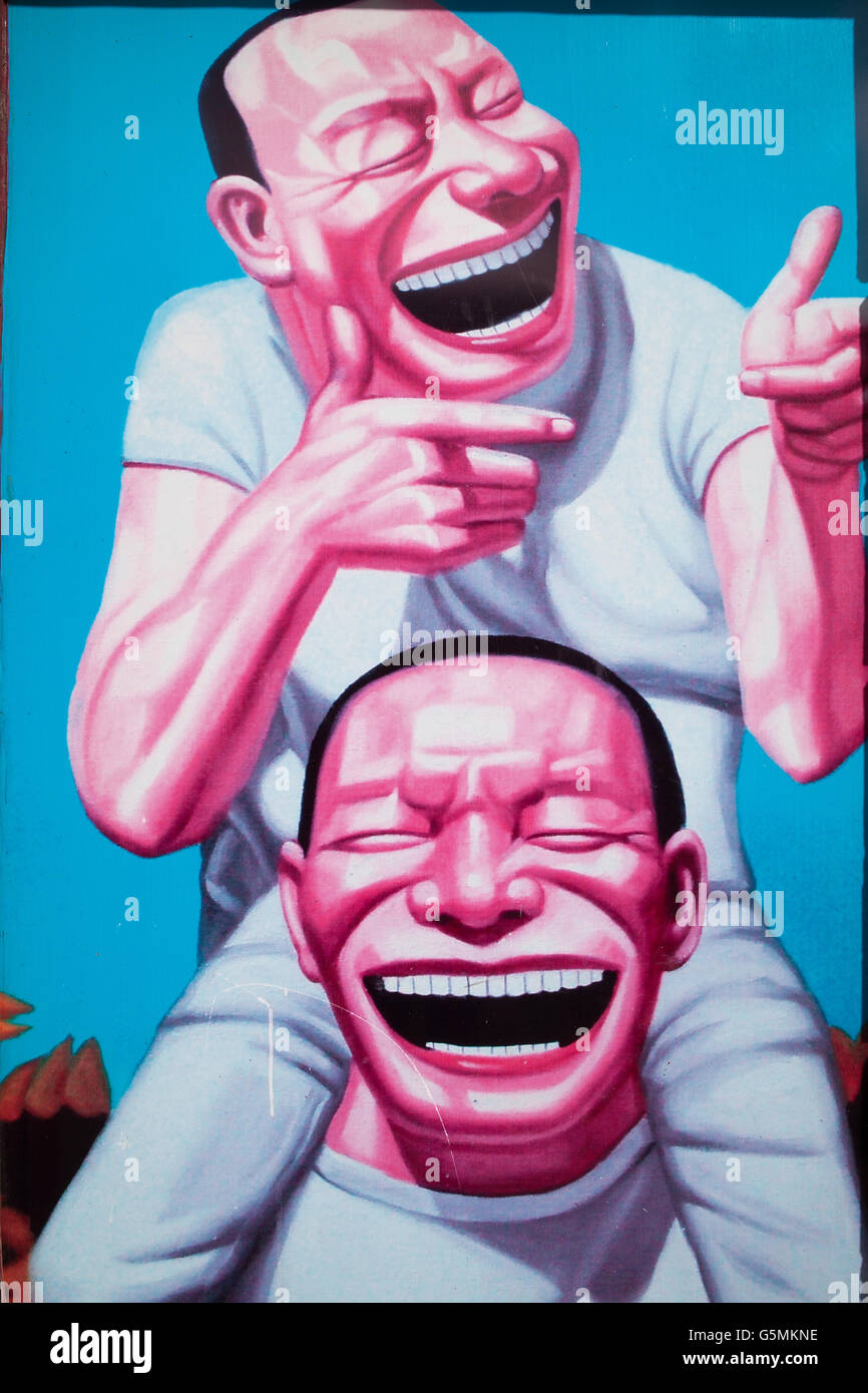 Montevideo Graffiti of  two grinning men in white. Stock Photo