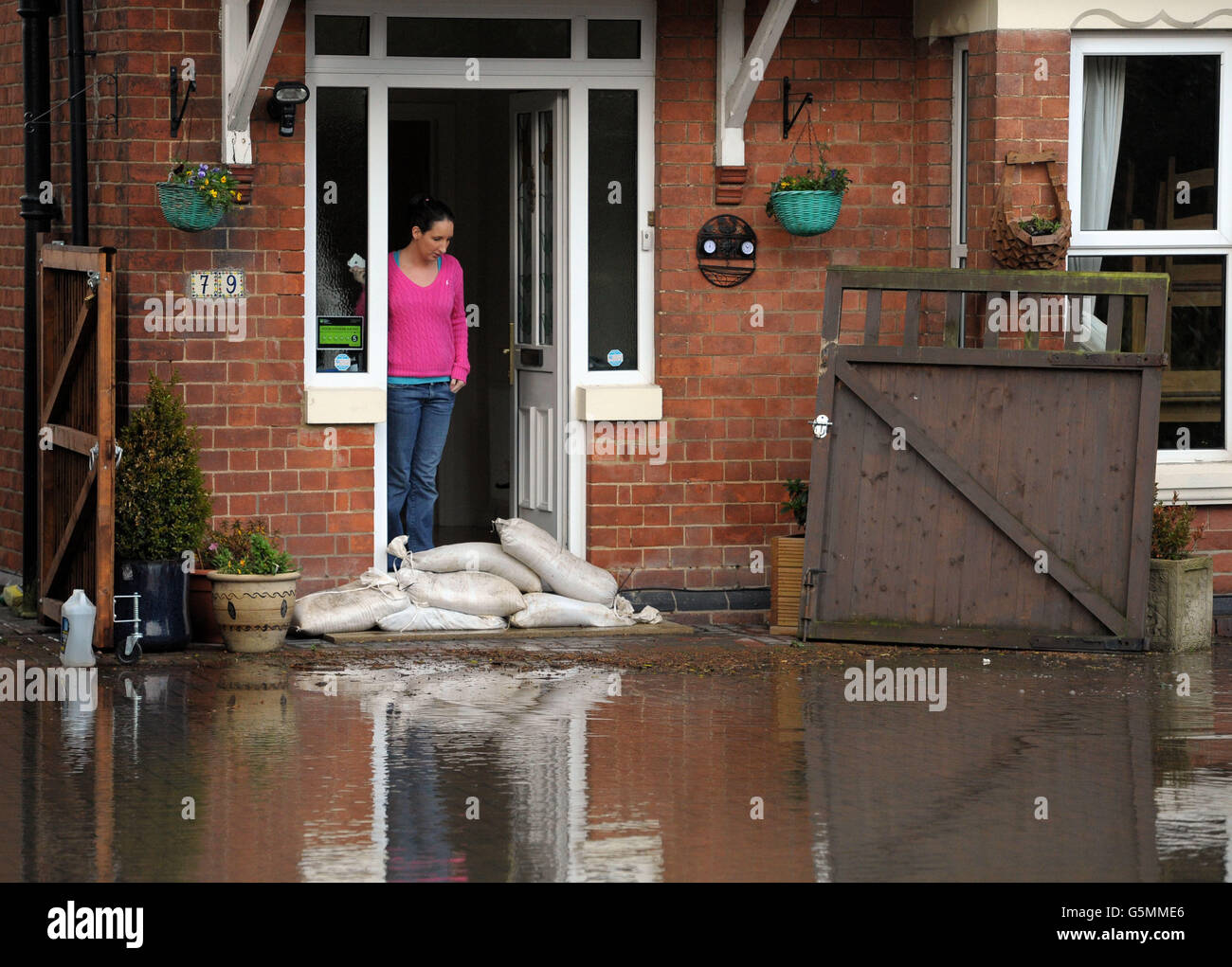 A woman watches rising floodwater in Gloucester. Thousands of drivers