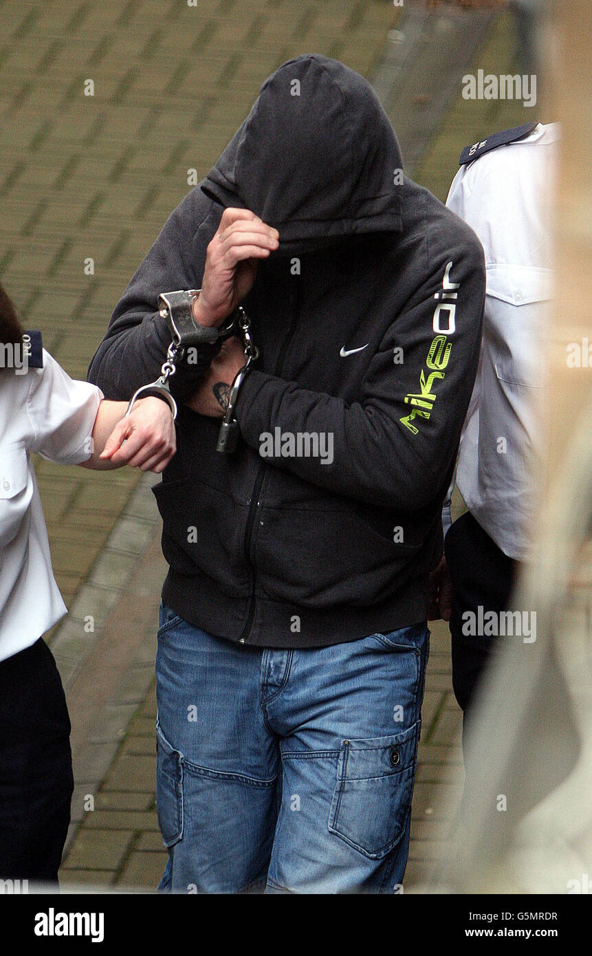 Paul James Manolito Toland hides his face as he is remanded into custody at Ballymena Magistrates court. Stock Photo