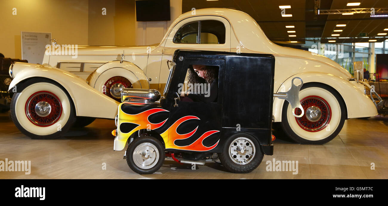 Cherrie Silver from Bonhams tries out the Windup, the world's smallest  roadworthy car beside a 1935 Pierce-Arrow Model 845 which will both be sold  at auction on Monday at Mercedes-Benz World in, image size:1300x692