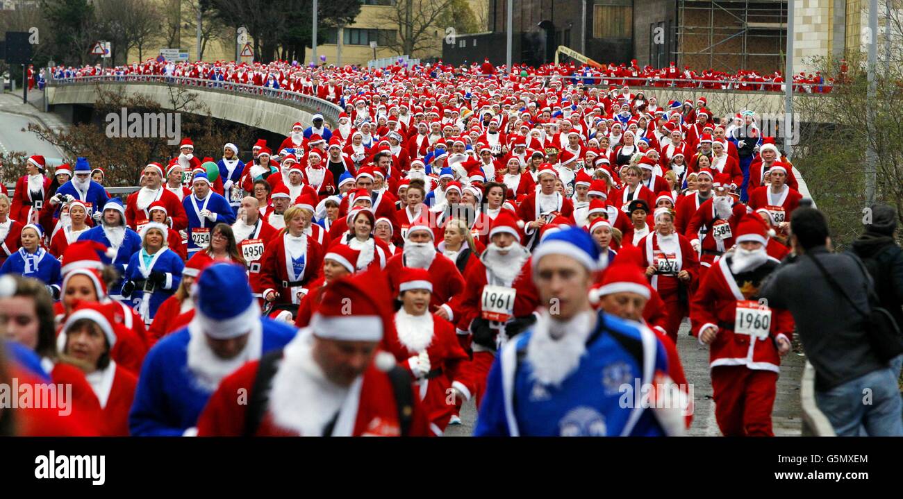 Santa dash. Runners dressed in red and blue Santa costumes take part in the RunLiverpool Santa Dash 2012 in Liverpool. Stock Photo