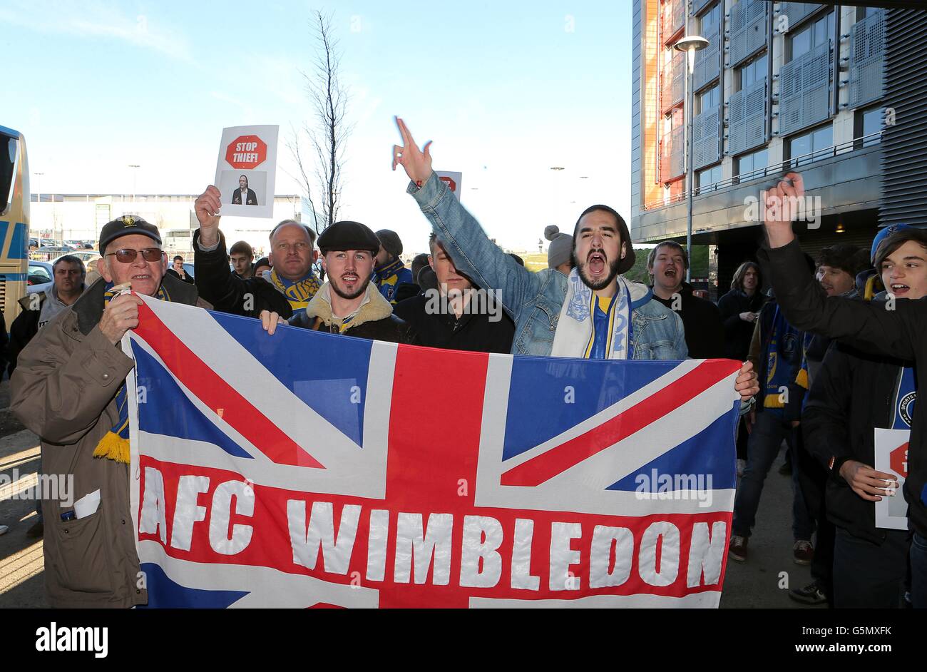 AFC Wimbledon fans hold up a flag supporting their team outside stadium ...